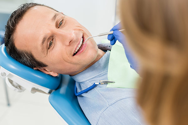 A man having his teeth cleaned at the dentist.