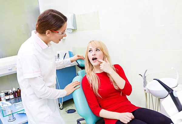 Woman in need of tooth abscess treatment at the dentist.