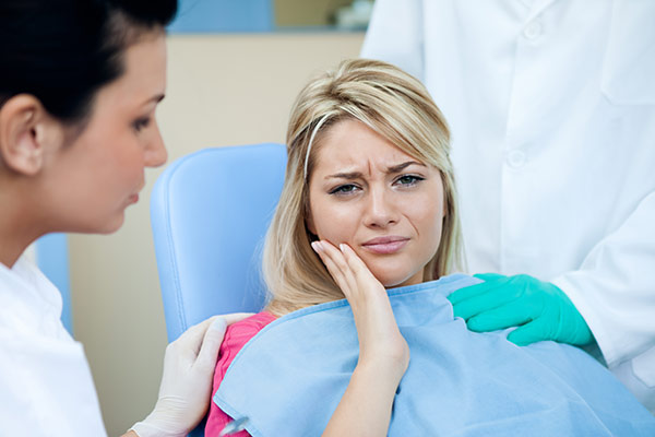 A woman with tooth pain due to an oral piercing.