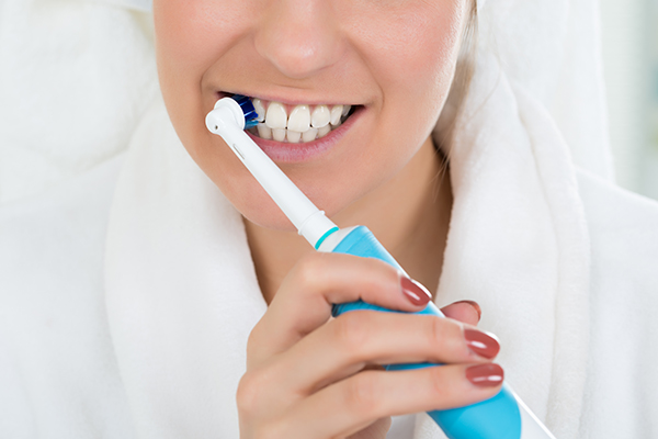 A woman with an electric toothbrush