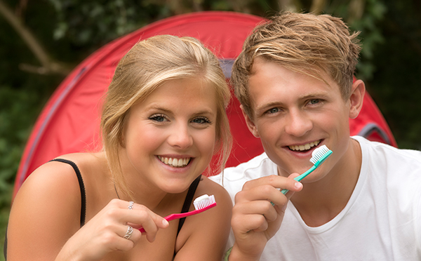 Two people camping with manual toothbrushes