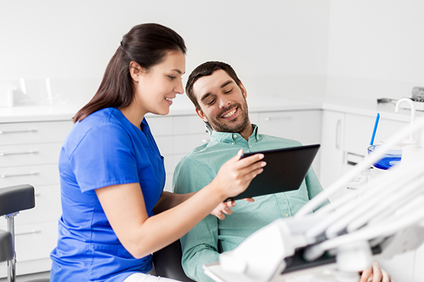 Dental hygienist with patient discussing periodontal disease treatment options.