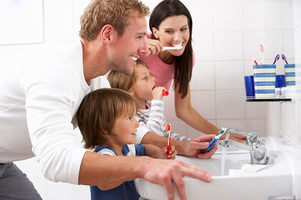 Parents teaching their children how to brush their teeth.