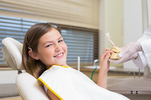 A child smiling at the dentist after overcoming her fear of the dentist.