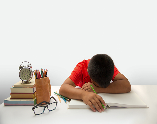 Tired child sleeps on his schoolbooks. pediatric sleep apnea