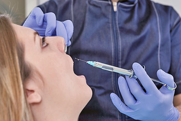 Woman receiving a dental anesthetics in her mouth. 