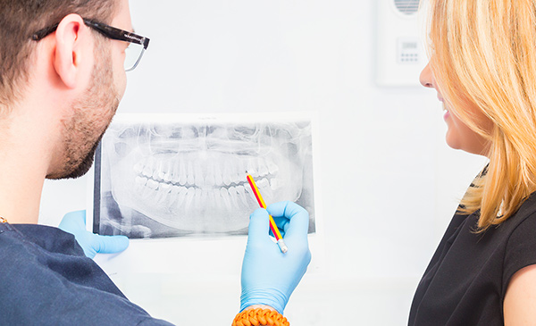 Dentist discussing a dental x-ray with his patient | dental x-ray safety