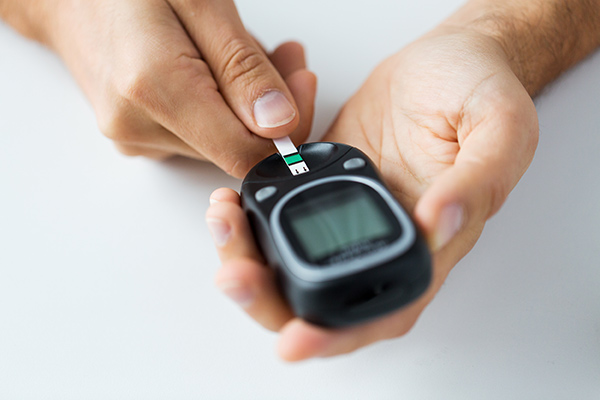 Man testing blood sugar levels with a glucometer and test strip.